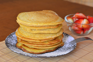 Stack of sweet pancakes with strawberry and icing sugar