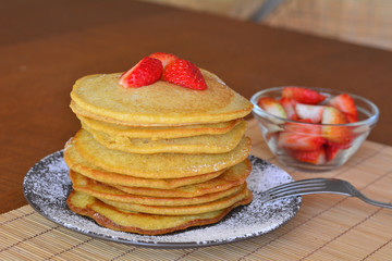 Stack of sweet pancakes with strawberry and icing sugar