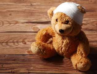 Plush Brown Teddy Bear with Bandaged on the Table