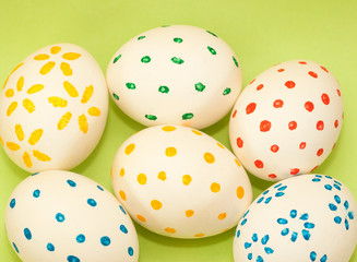 six spotted easter eggs on green background