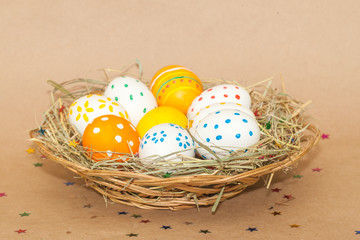 eight easter eggs in basket with hay