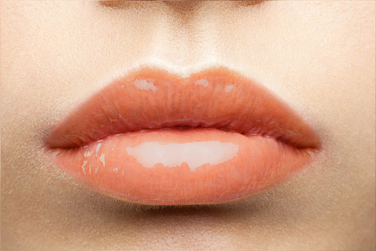 Glossy peach-colored lips