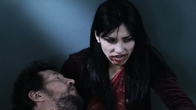 Sad female vampire with dead boyfriend attacking camera