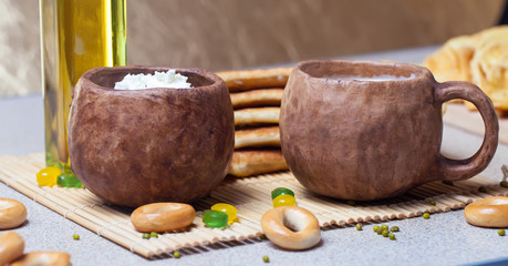 Fried pies, cheese, sunflower oil, milk and bagels on a plate cl