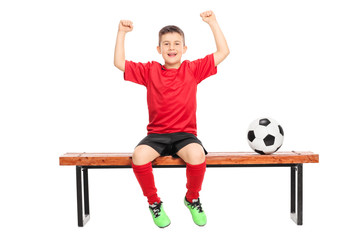 Joyful junior soccer player gesturing happiness