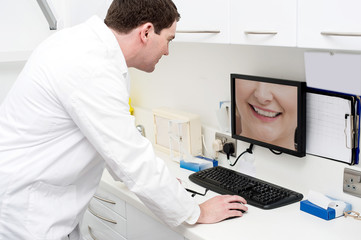 Dentist using computer in dental clinic