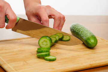 Woman cutting cucumber