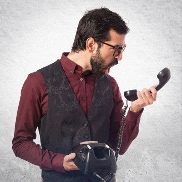 Man wearing waistcoat talking to vintage phone