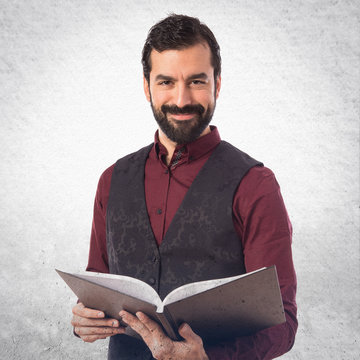 Man wearing waistcoat reading book