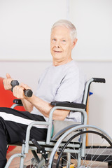 Alter Mann im Rollstuhl trainiert mit Hanteln