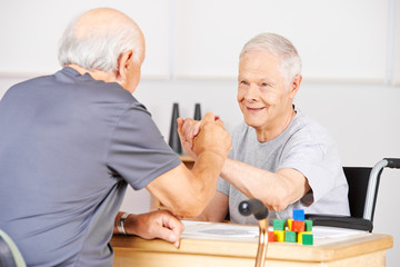 Zwei alte Senioren halten Hände im Pflegeheim