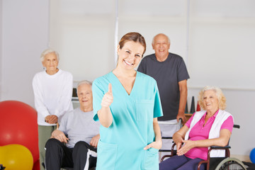 Physiotherapeut vor Gruppe Senioren hält Daumen hoch