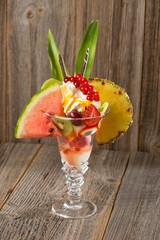 Früchte-Eisbecher auf Holzhintergrund