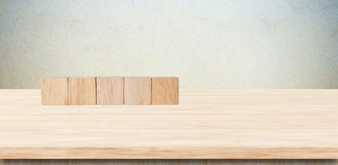 Five wooden cubes on table over grunge cement wall