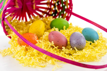 colored Easter eggs, yellow chicks and candy in a basket