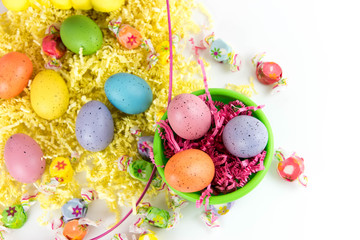 colored Easter eggs, yellow chicks and candy in a basket