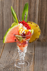 Früchte-Eisbecher auf Holzhintergrund