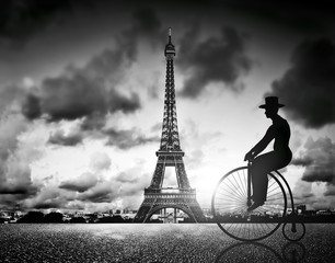 Man on retro bicycle next to Effel Tower, Paris, France.