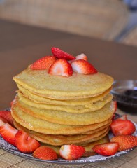 Stack of sweet pancakes with strawberry and icing sugar