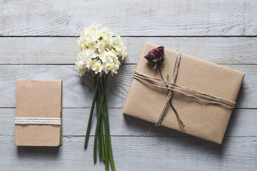 White narcissus flowers, notebook and present on wood