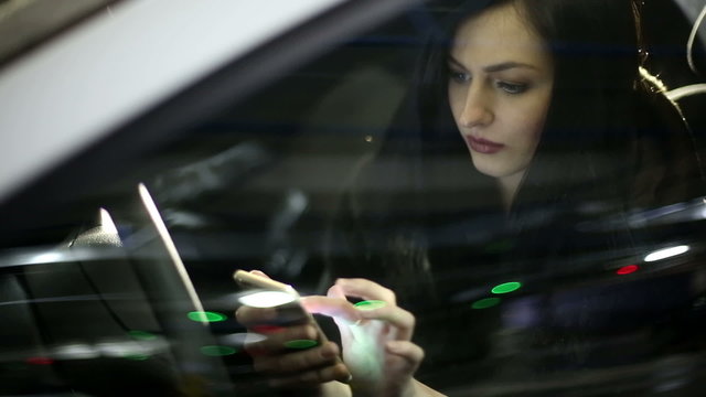 Young attractive woman using mobile phone in the car