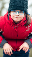 Portrait of a little girl in a black cap and blue eyeglasses on