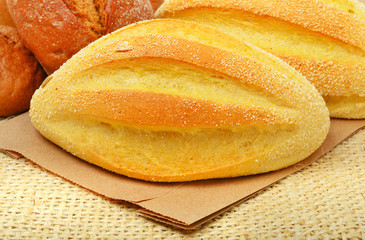 Fresh wheat buns on the sacking background.