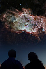 Fototapeta na wymiar Silhouettes of couple looking at stars. Starry night sky with