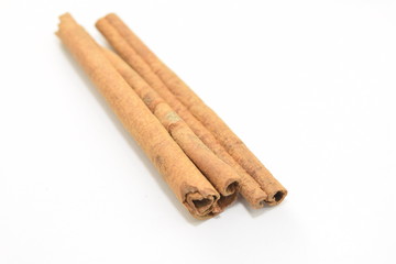 Cinnamon sticks stacked on white background.