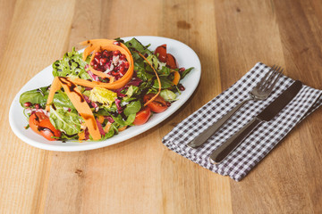 Salat auf kleinem Teller mit Messer und Gabel