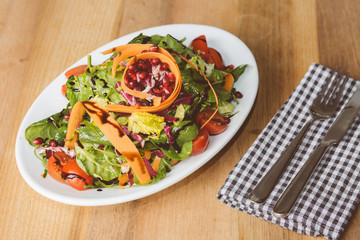 Salat auf kleinem Teller mit Messer und Gabel