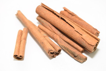 Cinnamon sticks stacked on white background.
