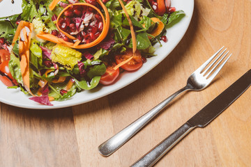 Salat auf kleinem Teller mit Messer und Gabel // Oben Ansicht