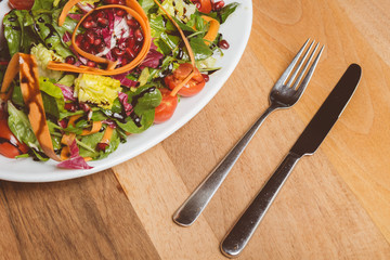 Salat auf kleinem Teller mit Messer und Gabel // Oben Ansicht