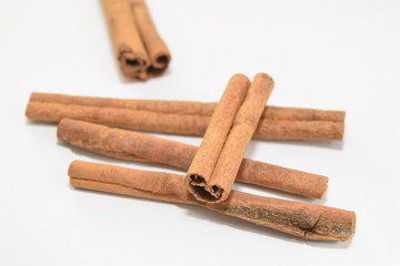 Cinnamon sticks stacked on white background.