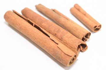 Cinnamon sticks stacked on white background.