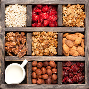 granola, oatmeal, nuts, berries in a wooden box. Top view.