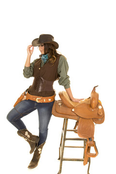 cowgirl stand by saddle on stool