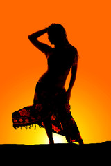 silhouette of woman in bikini and sarong blowing