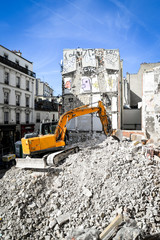 Excavator on building ruins in residential area