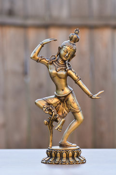 Tara Avalokitesvara bodhisattva - indian statue, made of bronze, on wooden background