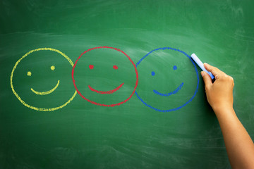 drawn smileys different colors on blackboard