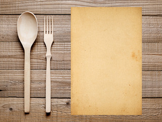 Blank paper, fork and spoon on wooden table