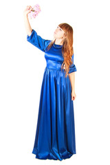 Fototapeta premium Beautiful young woman in a long blue evening dress with a small