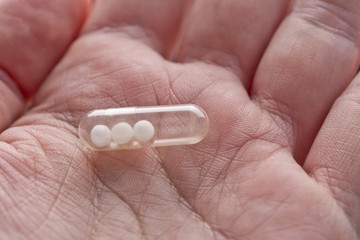 capsule pill with homeopathy in macro hand