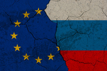 Cracked EU vs Russia flags. Ukrainian crisis conceptual image.