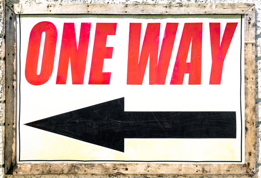 Vintage one way sign with black arrow showing the direction