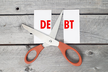 Cut debts concept against a wooden background
