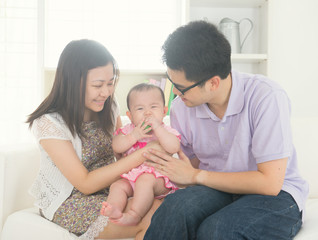 asian parent playing with baby girl in livingroom