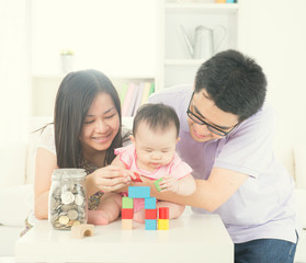 asian parent playing with baby girl in livingroom